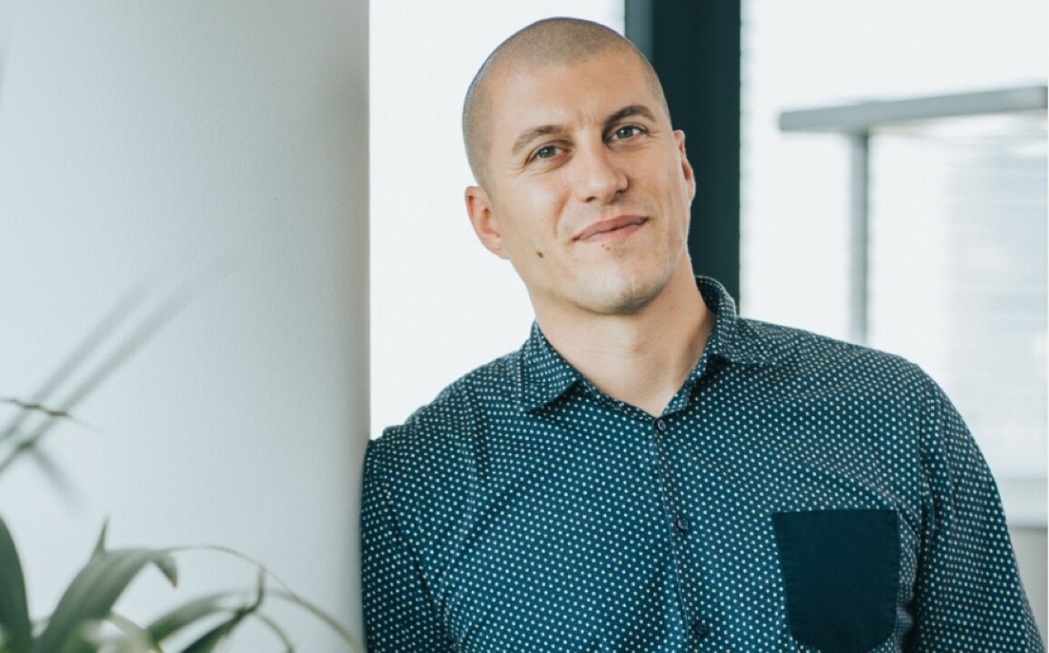 Francesco Cocco, HR Business Partner, standing in a modern office space with a relaxed and confident expression.