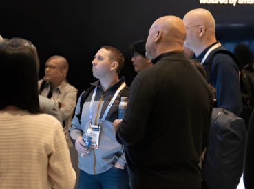 Attendees at AutoSens Europe 2024, gathered around a presentation, showcasing interest in the latest automotive sensor technologies.