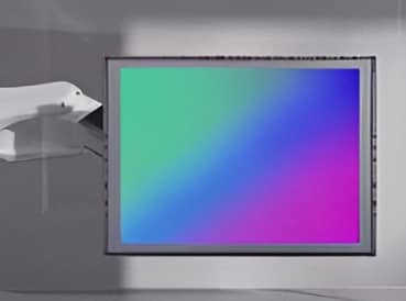 A flat-panel display with a vibrant green-to-purple gradient, positioned beside a white projector arm