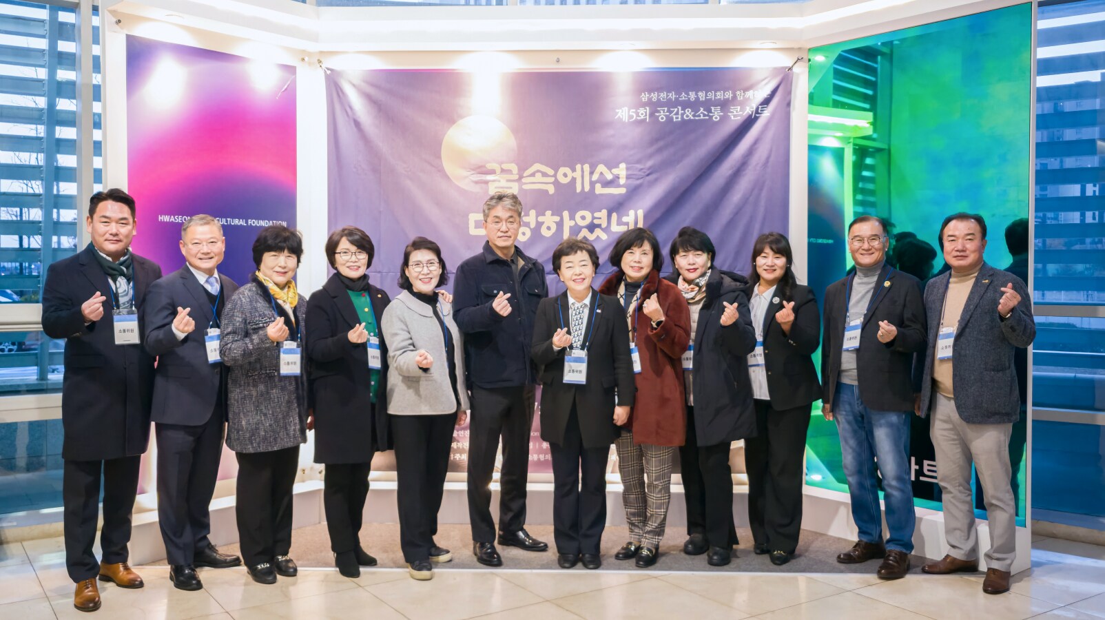 삼성전자 공감&소통 콘서트 행사장에서 공연 포스터 앞에 선 참가자들이 단체 기념사진을 촬영하는 모습