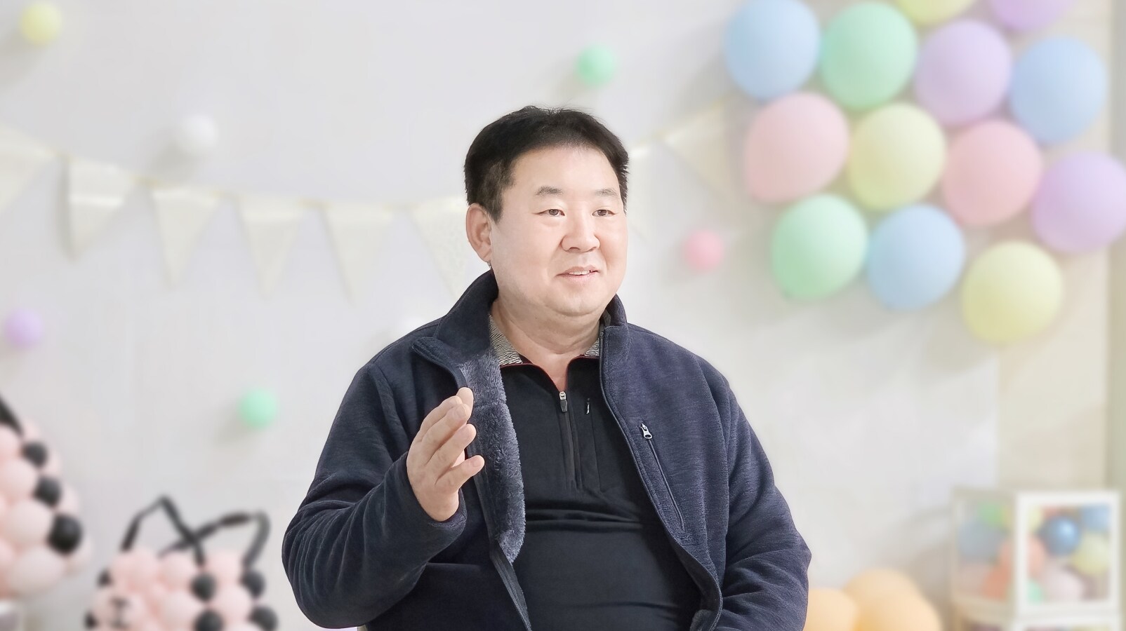 삼성전자 공감&소통 콘서트 인터뷰 공간에서 풍선 장식 배경 앞에 앉아 이야기를 전하는 참가자 모습