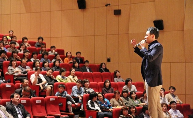 김창옥 교수가 청중들을 향해 강연을 하고 있는 모습입니다.