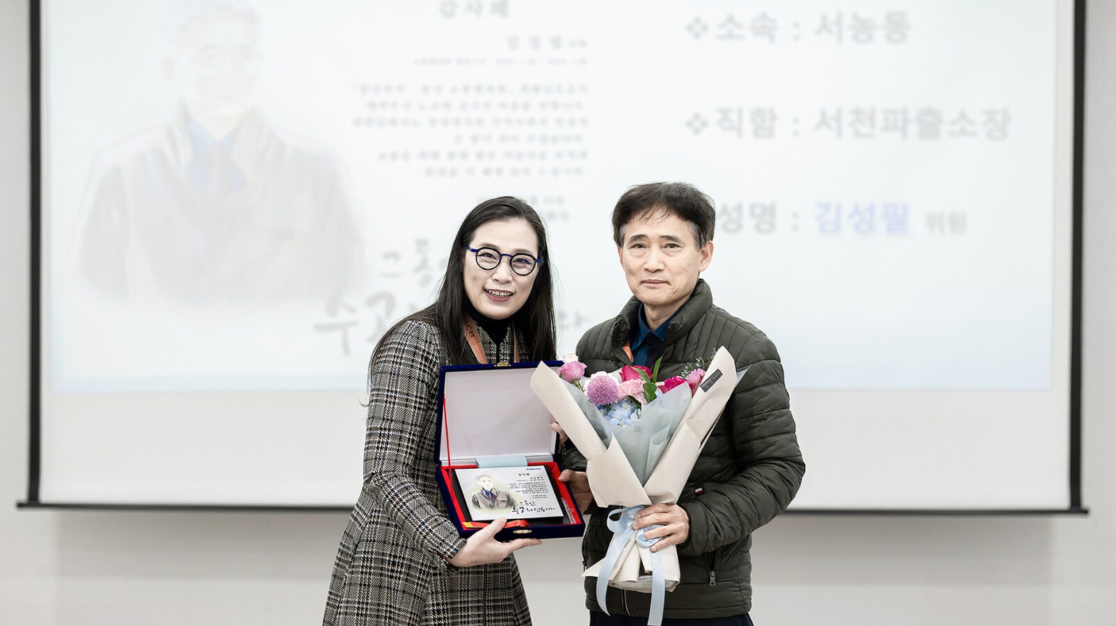 감사패와 꽃다발을 들고 있는 前 서천파출소장 김성필 위원과 고정미 센터장