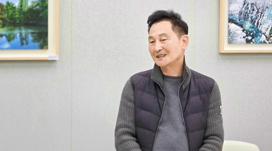 11월 정기회의에서 권영지 대표위원이 미소를 지으며 발언하는 모습과 배경에 전시된 풍경화