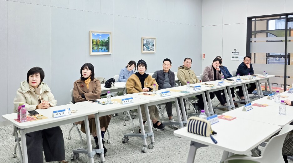소통협의회 위원들이 양쪽 테이블에 앉아 발표를 집중해서 듣는 회의실 풍경