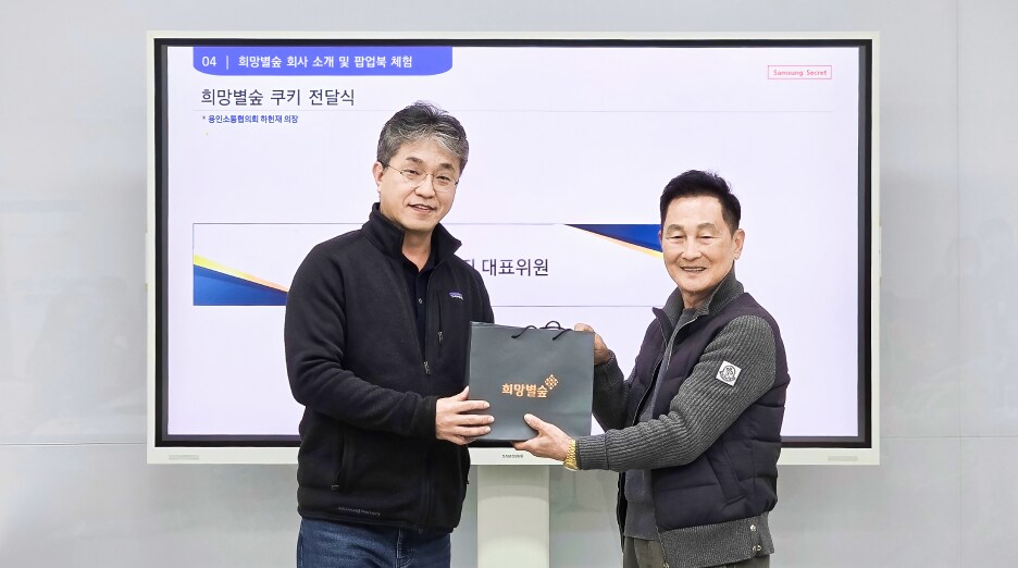 행사 현장에서 희망별숲 기념 패키지를 전달받으며 악수하는 권영지 대표위원