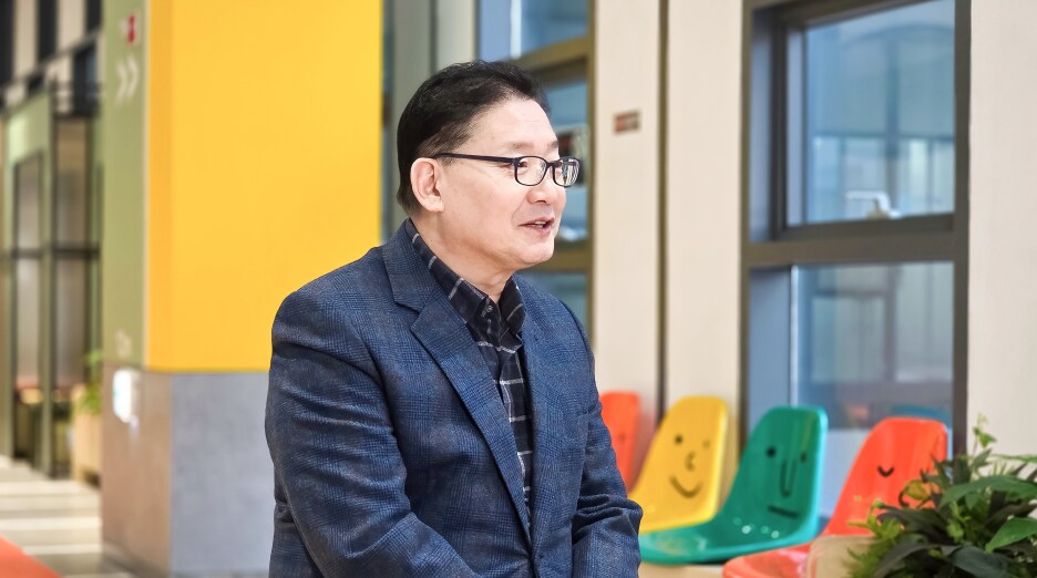 밝은 복도에서 미소를 띠며 인터뷰에 응하는 이동범 위원