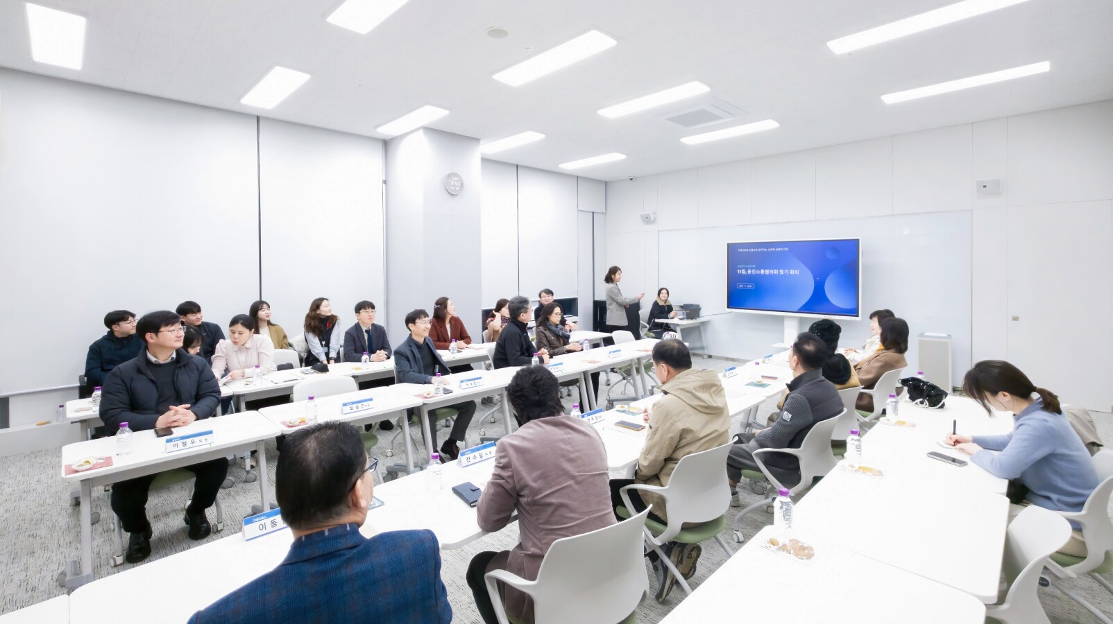 희망별숲 2층 교육센터에서 열린 회의에서 참석자들이 U자형 테이블에 모여 발표 화면을 보며 논의하는 장면