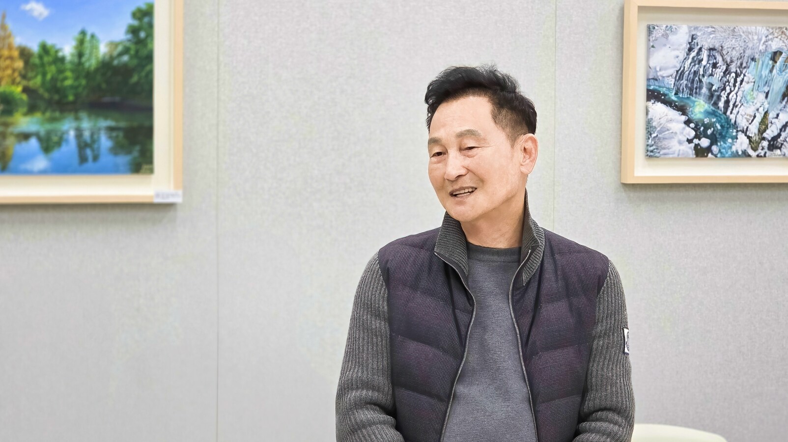 11월 정기회의에서 권영지 대표위원이 미소를 지으며 발언하는 모습과 배경에 전시된 풍경화