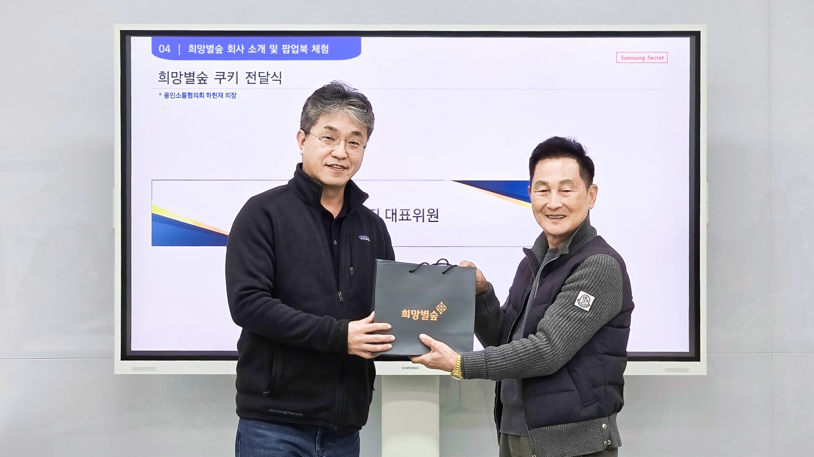 행사 현장에서 희망별숲 기념 패키지를 전달받으며 악수하는 권영지 대표위원