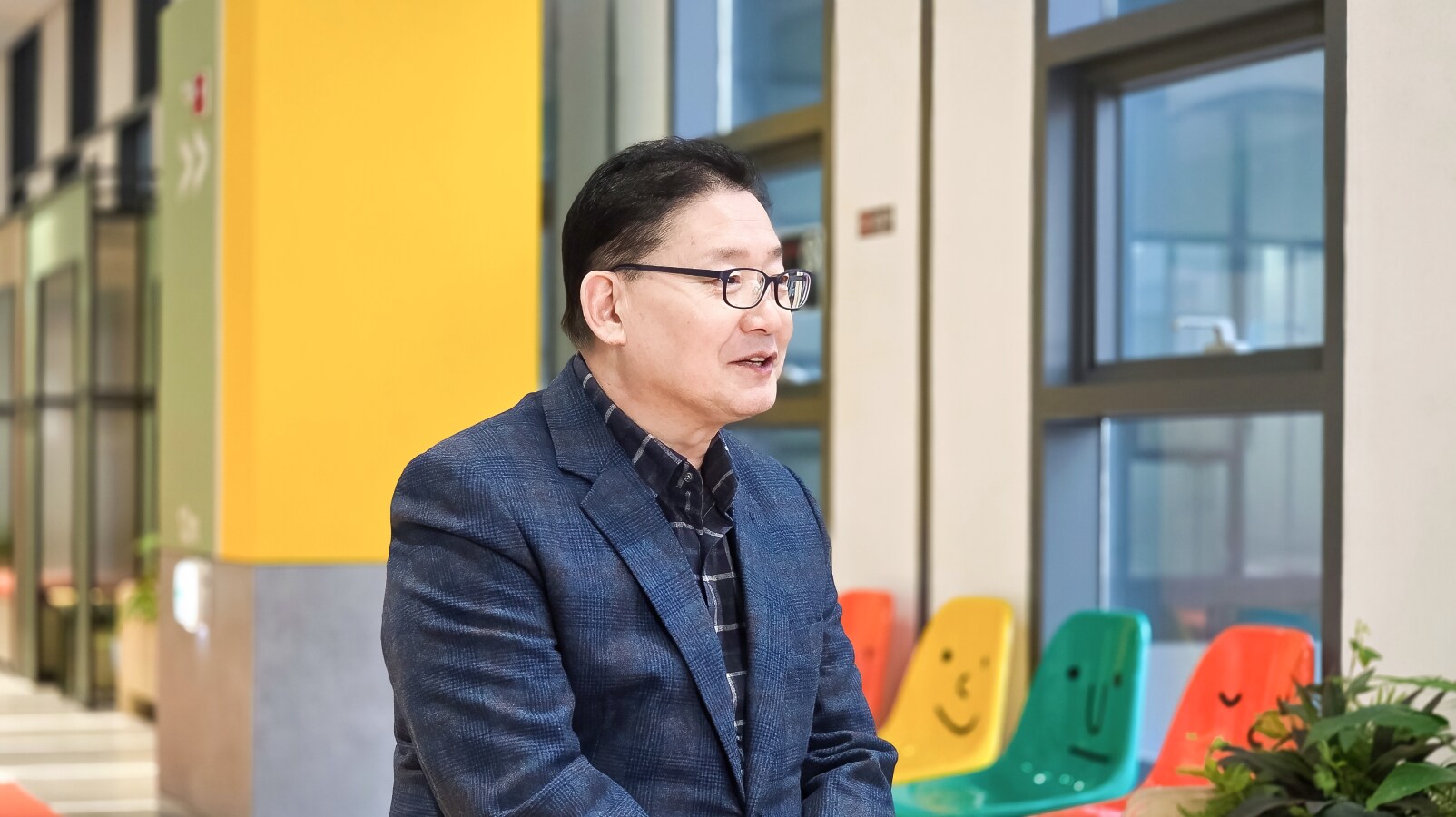 밝은 복도에서 미소를 띠며 인터뷰에 응하는 이동범 위원