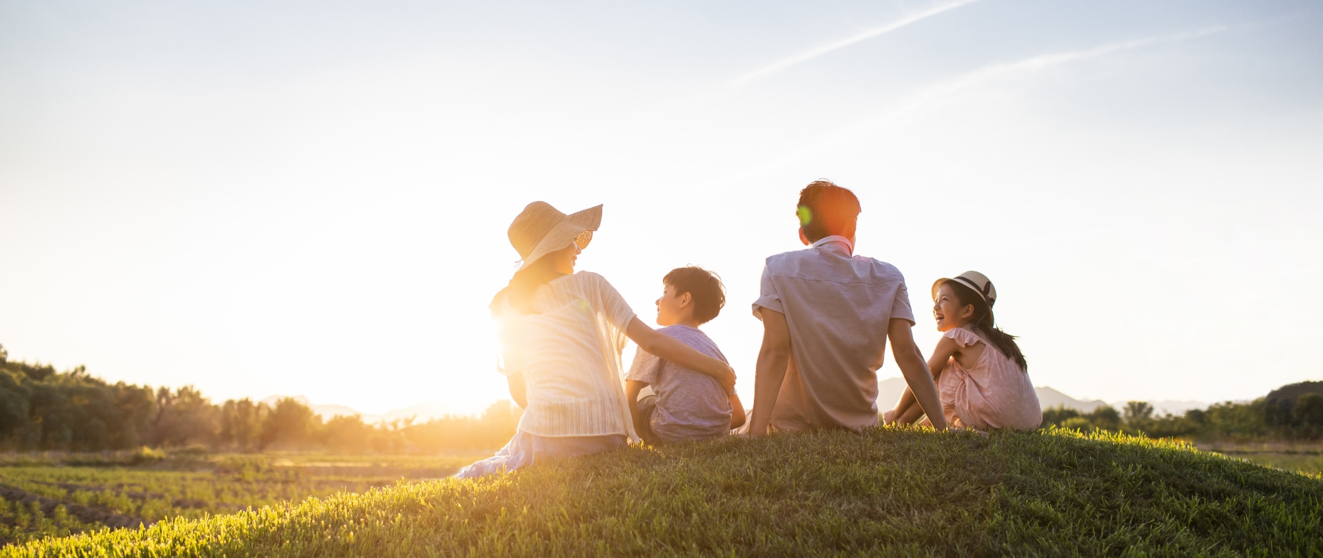 A picture of a family under the sun, looking at each other while basking in nature.