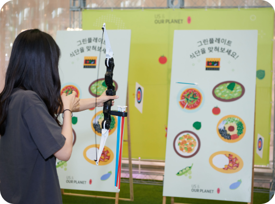 활을 쏘아 "그린플레이트 식단을 맞혀보세요!" 게임에 참여하는 참가자의 모습.
