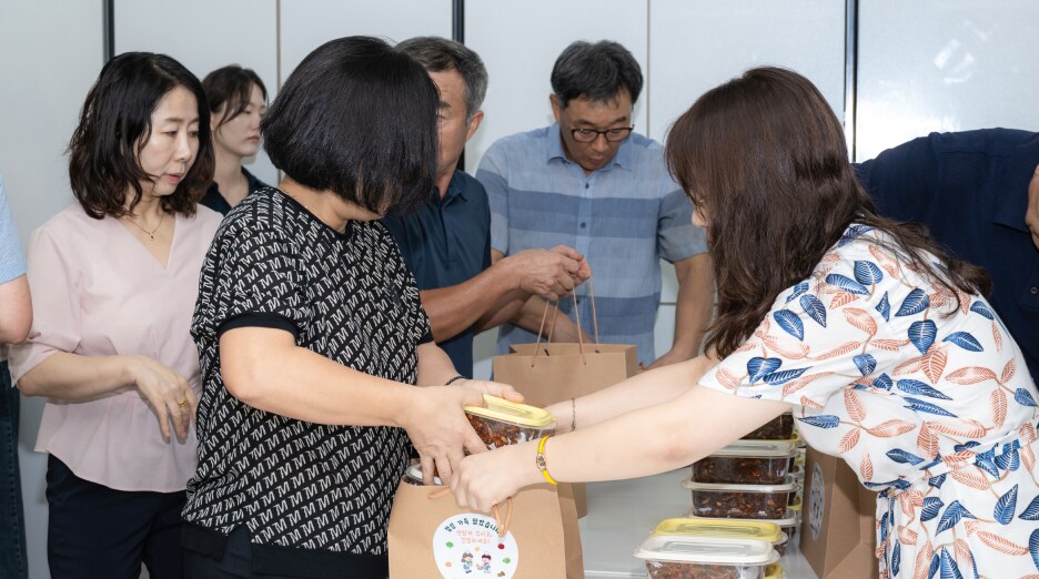 지역사회 나눔 봉사활동에 참여한 삼성전자-평택 소통협의회 위원들이 세 가지 반찬을 정성껏 포장해 쇼핑백에 담아 이웃에 전달하는 모습
