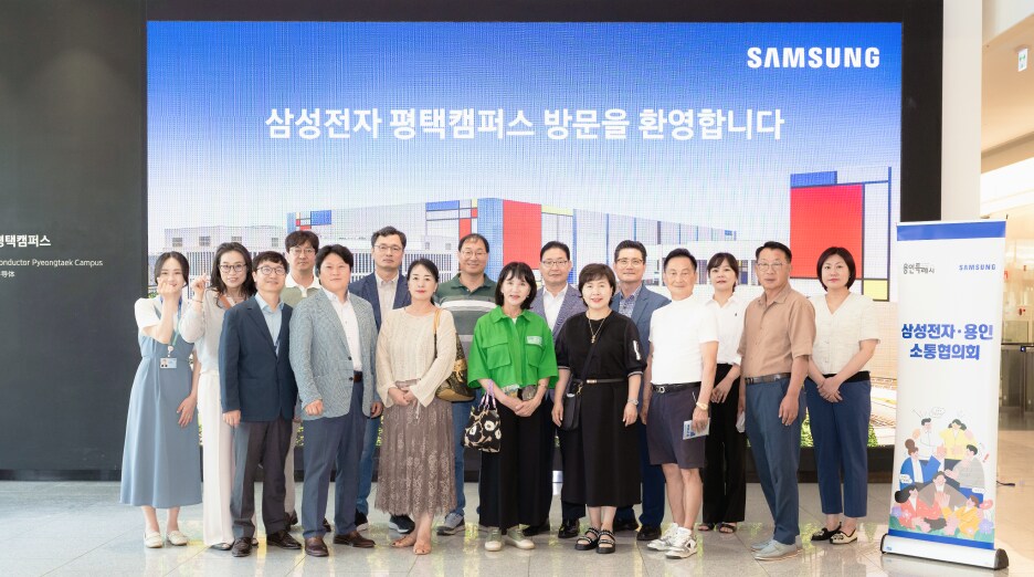 밝은 환영 안내판 아래, 삼성전자 평택캠퍼스 입구 홀에서 방문객들이 단체 사진을 촬영하고 있다.