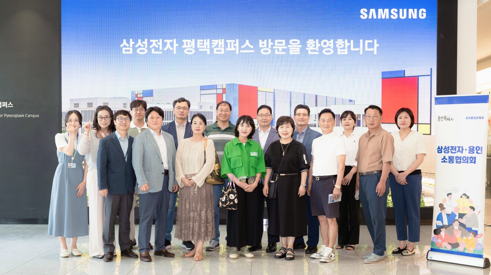 밝은 환영 안내판 아래, 삼성전자 평택캠퍼스 입구 홀에서 방문객들이 단체 사진을 촬영하고 있다.