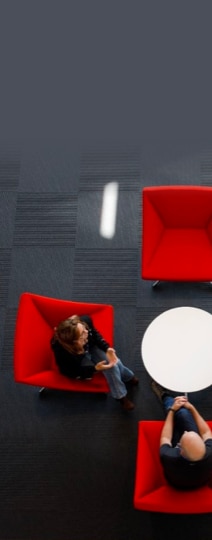 Top view of two people sitting on three red couches