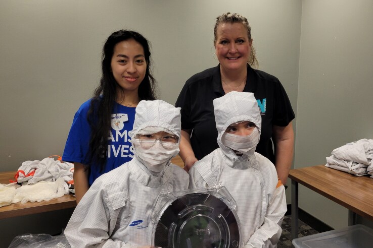 Students in cleanroom suits with educators