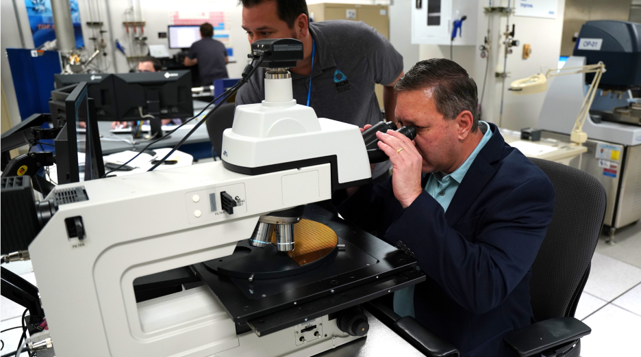 Rafael Lainez examining a wafer using a semiconductor inspection microscope.