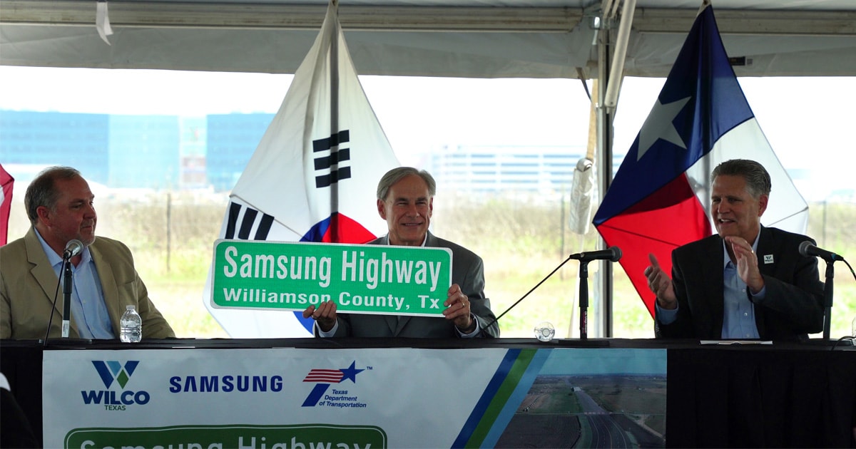 Gov. Greg Abbott holding a Samsung Highway sign gifted to him by Williamson County Pct. 4 Commissioner Russ Boles. 