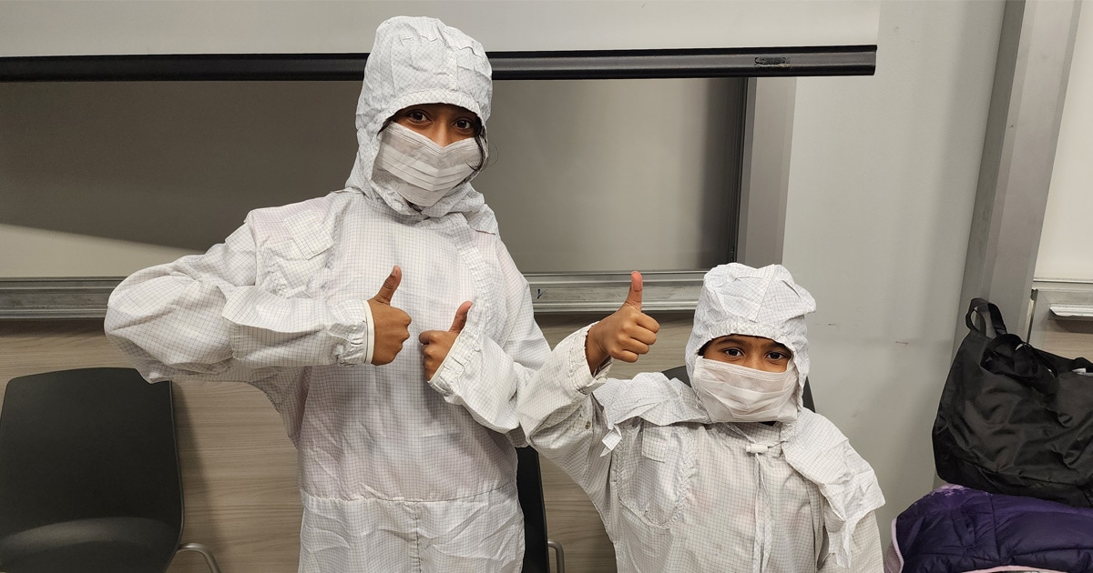 Children dressed up in the cleanroom smocks.