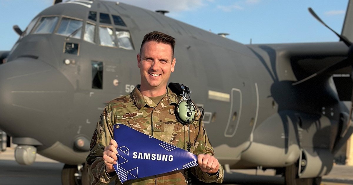 Andrew Kavanah representing Samsung while on deployment. Behind him is a HC-130J. 