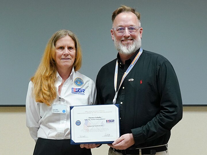 Tom Schultz and an ESGR representative stand side by side, smiling at the camera.