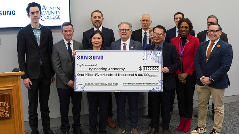 A group of professionals poses with a large ceremonial check from Samsung for $1.5 million, supporting the Engineering Academy at Texas A&M University and Austin Community College.