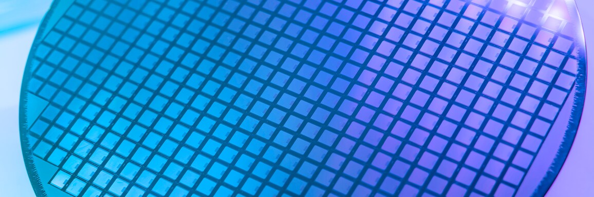 A close-up of a silicon wafer with a grid of microchips.