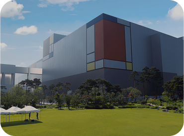A wide-angle view of a Samsung semiconductor fabrication plant with a modern, color-block exterior and landscaped greenery in the foreground.