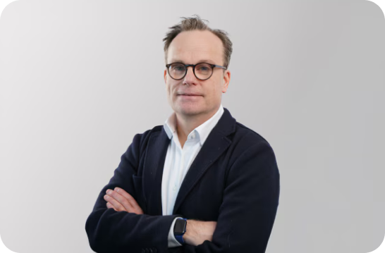 Professional portrait of Jens Kahrweg, President of EMEA Headquarters, standing against a neutral background in formal attire.