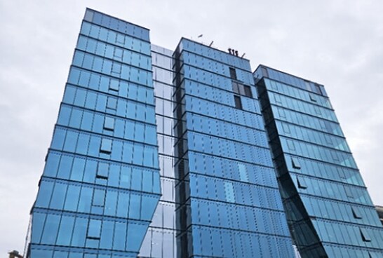 The Bengaluru Lab building, a striking modern structure with reflective blue glass panels and an angular, asymmetrical design.