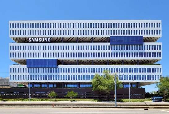 A modern Samsung office building with a bold horizontal design and alternating blue and white window patterns.