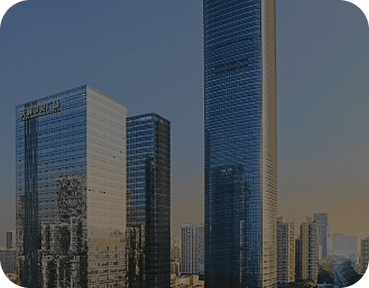 High-rise office towers with glass façades reflecting the evening light, including a Samsung-branded skyscraper in a modern cityscape.