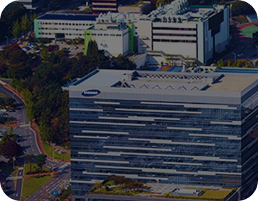 Aerial view of the Samsung corporate building, a modern multi-story glass structure surrounded by roads and green landscaping.