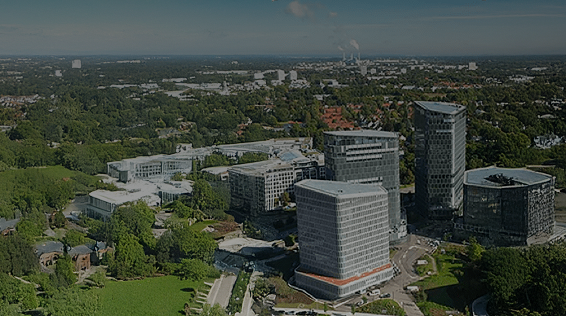 Aerial view of Samsung's European office complex surrounded by lush greenery and residential areas under a clear sky.