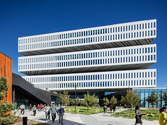 A view of the Samsung Semiconductor headquarters in Silicon Valley, showcasing its futuristic tiered structure and open green space bustling with activity.