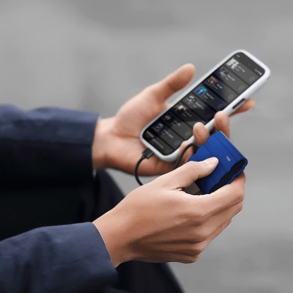 A person using a Samsung Portable SSD T7 Shield connected to a smartphone.