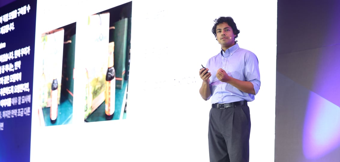 Professor Ranjay Krishna explaining the performance of open-weight AI models on stage