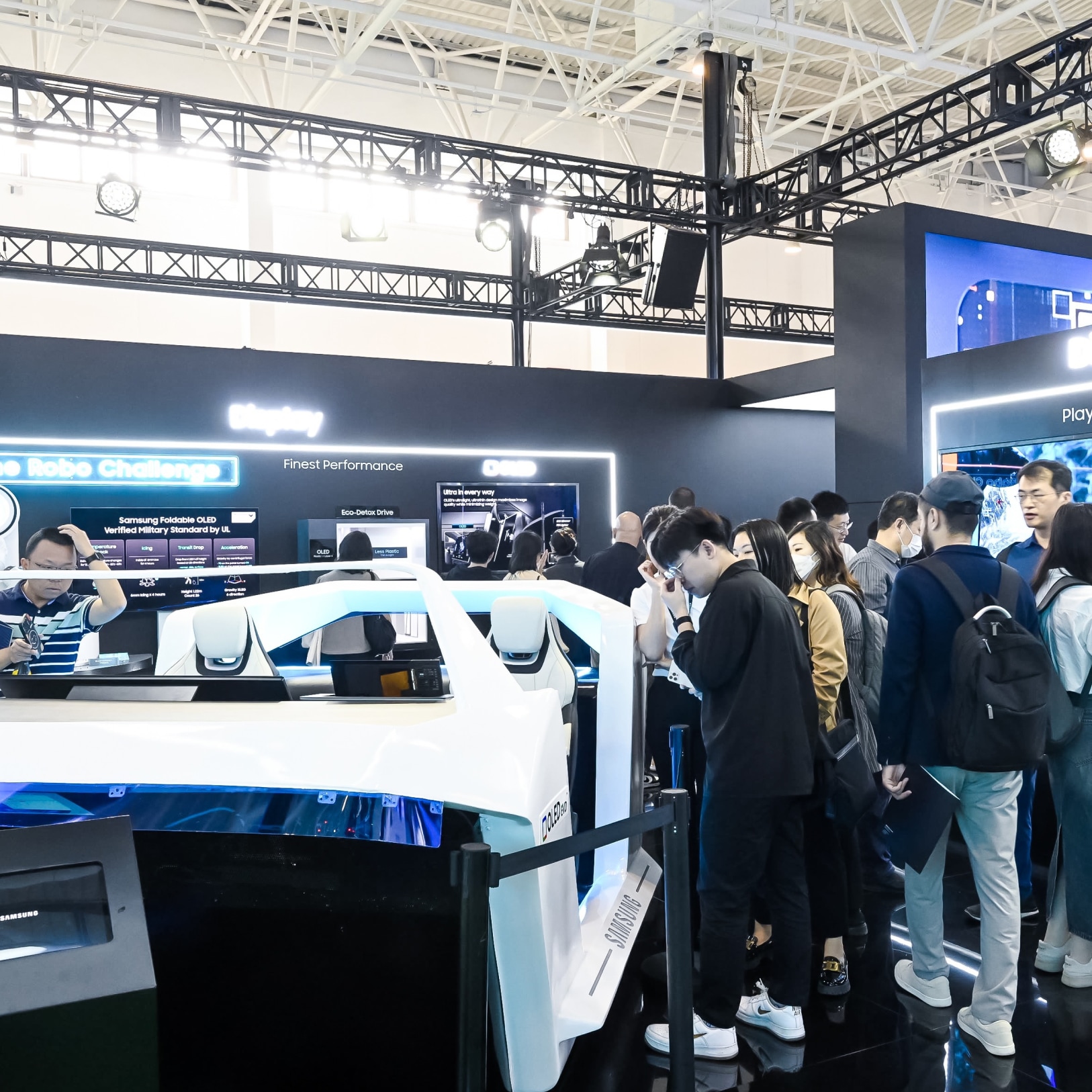2024年北京车展的参观者正在与一辆白色未来主义汽车原型展台互动，并参观信息展示。