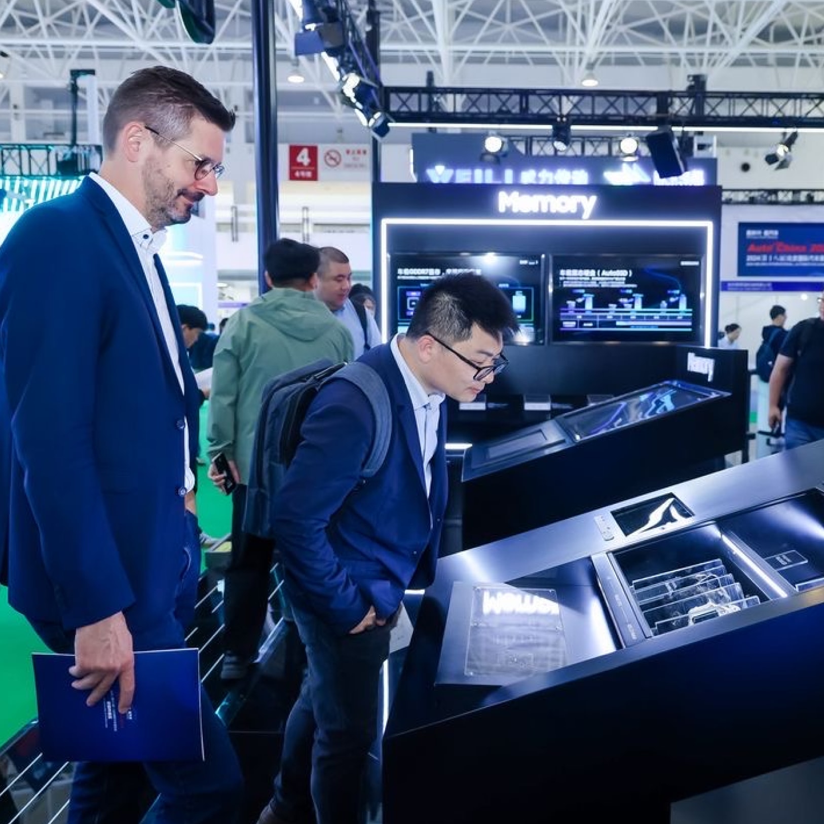 2024年北京车展上，参观者们在三星公司的信息展台上仔细观察LED技术的展示。