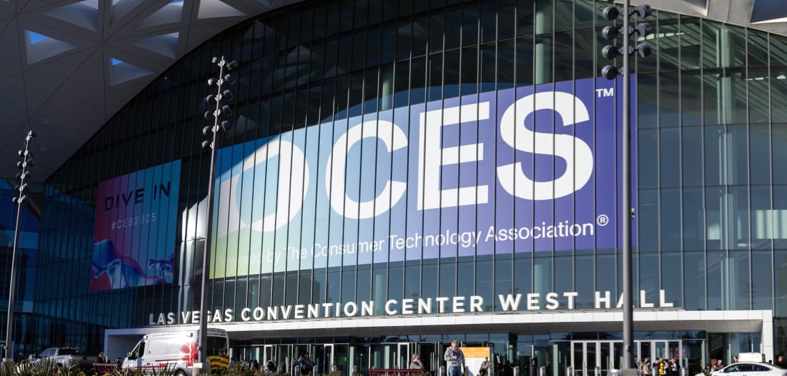 The exterior of the Las Vegas Convention Center during CES 2025, featuring a large, vibrant CES banner under a striking geometric roof.