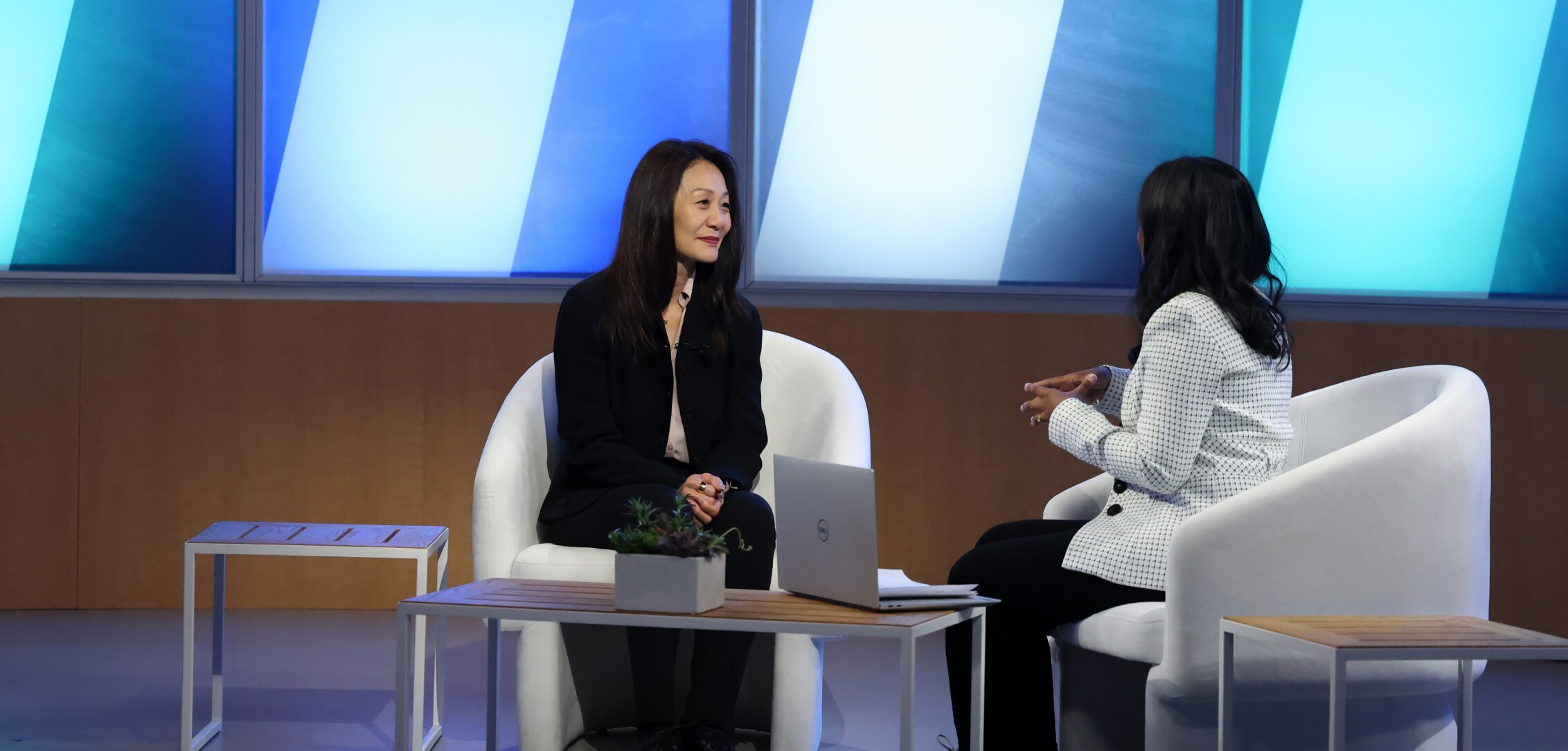 A professional interview setup at Dell Technologies World 2024 featuring two women conversing, with a modern and brightly lit background.