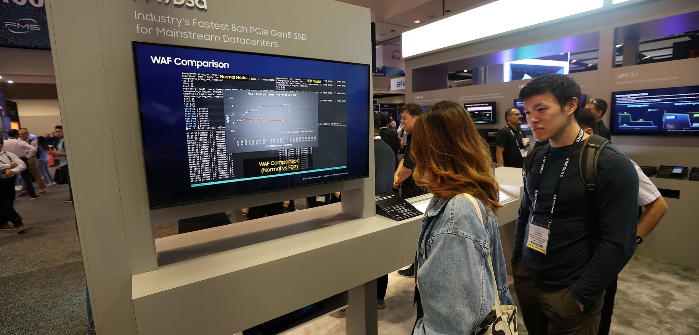 Attendees examining a display featuring the Samsung PM9D3a technology at FMS 2024, with detailed specifications shown on the screen.