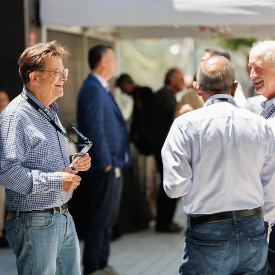 Professionals dressed in casual attire enjoying light-hearted conversations at a networking event