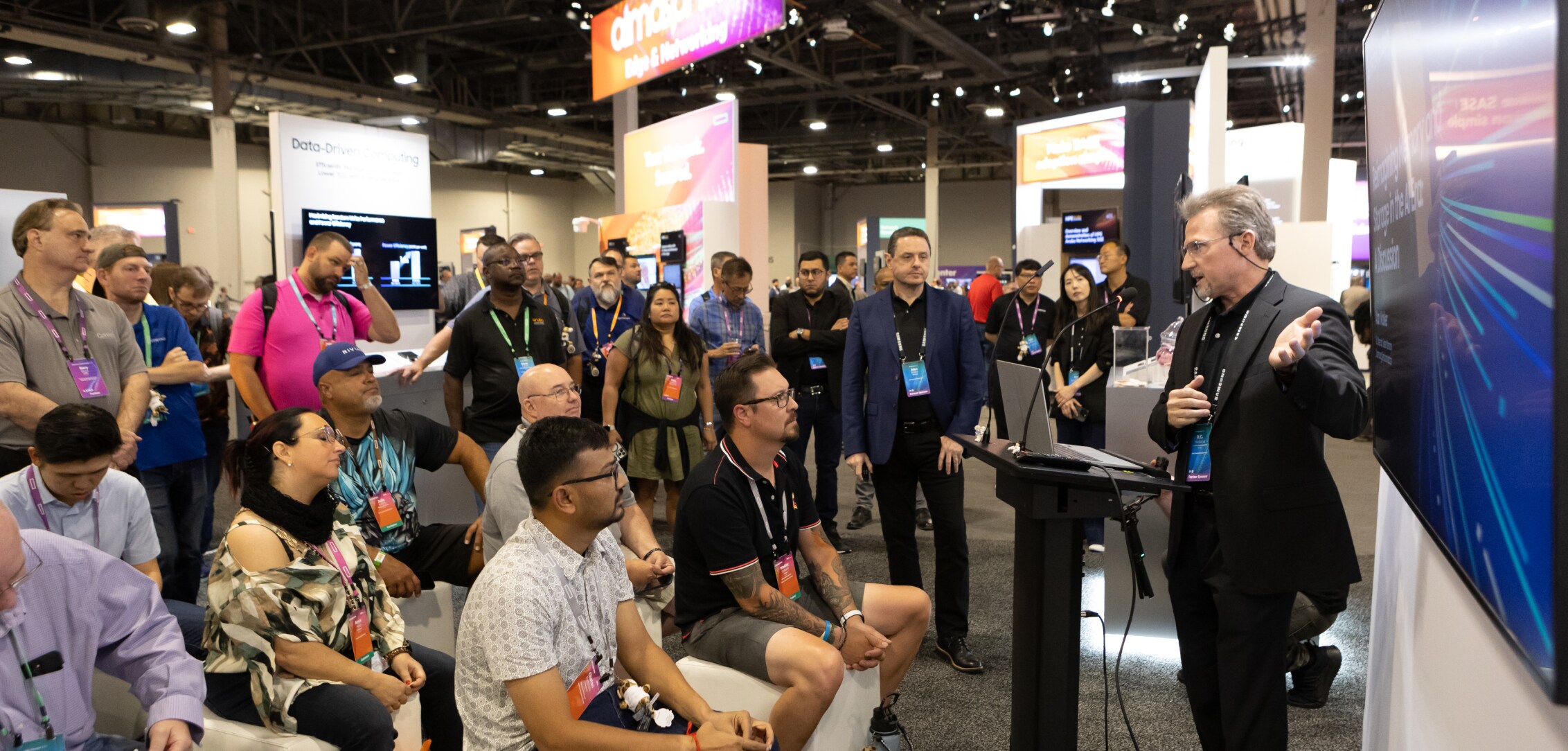 A professional presentation at HPE Discover 2024, with attendees attentively listening at the Samsung booth.