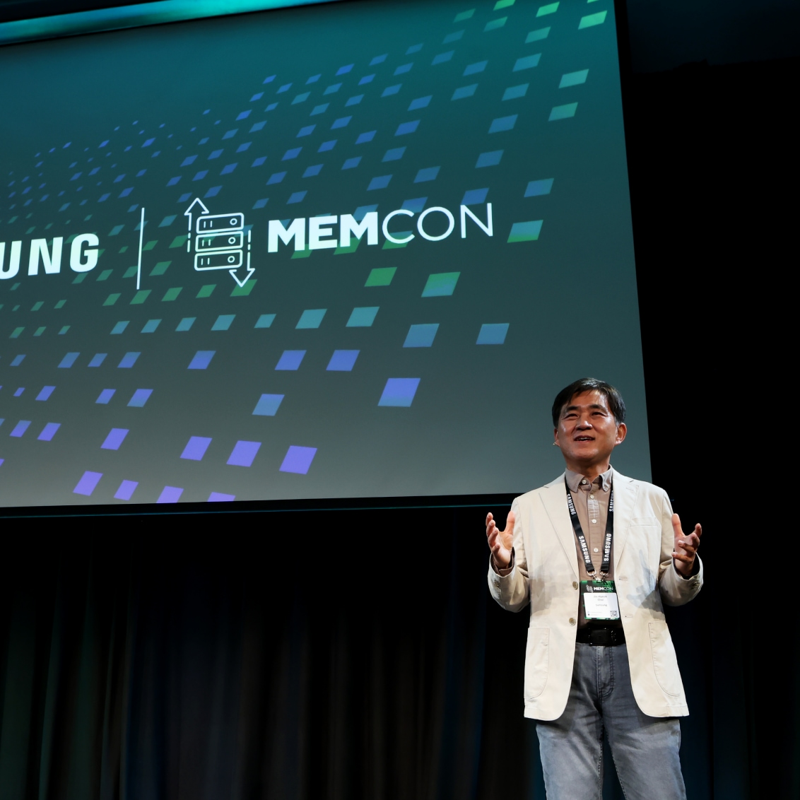 A man presenting at a conference with the word 'MEMCON' on the screen behind him.