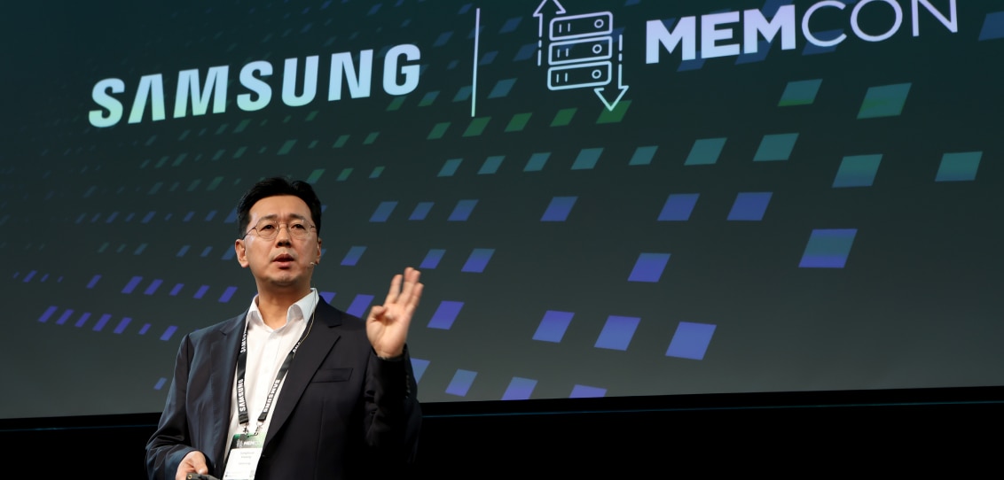 A speaker gesturing with their hand during a presentation at a MEMCON 2024 with the Samsung logo in the background.