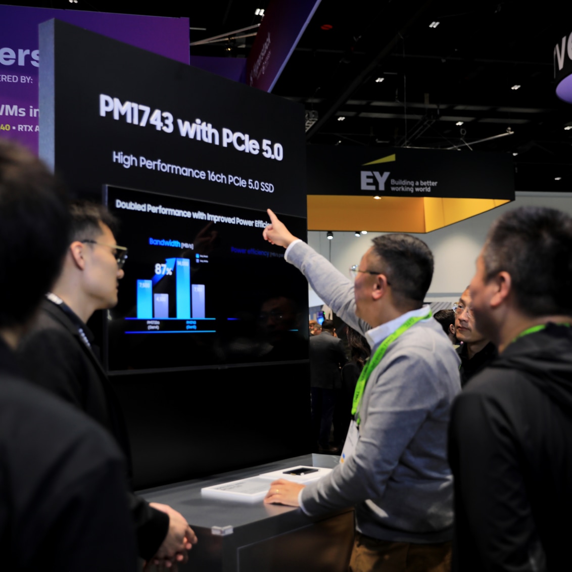 People engaged in a discussion NVIDIA GTC 2024 booth featuring PCIe 5.0 SSDs.