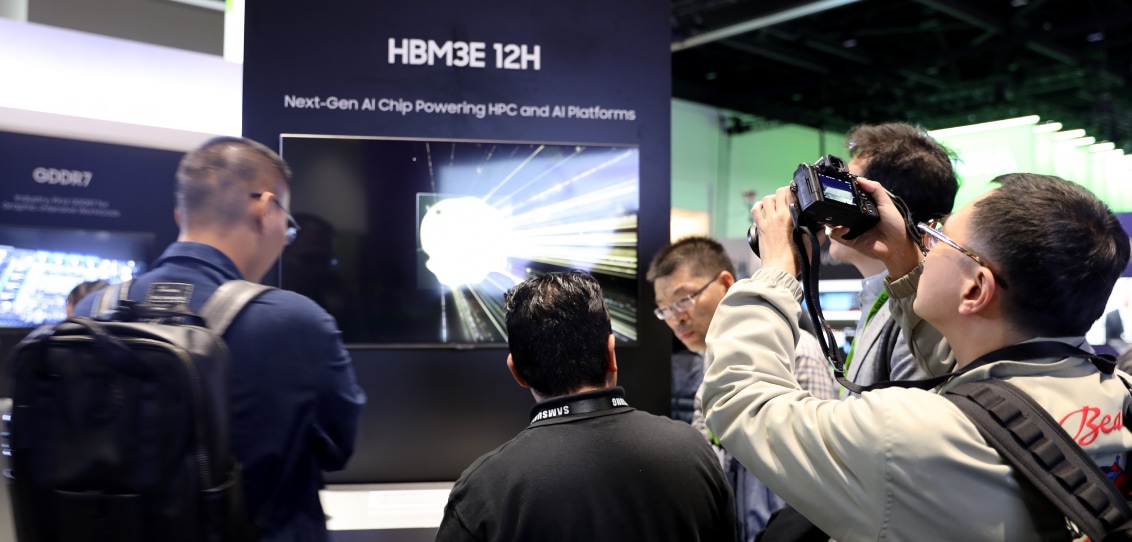 Attendees and a photographer capturing a presentation on a next-gen AI chip